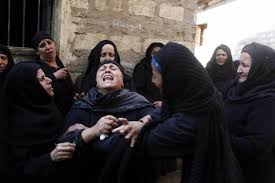 A Muslim widow, overcome with grief, surrounded by comforting sisters and friends